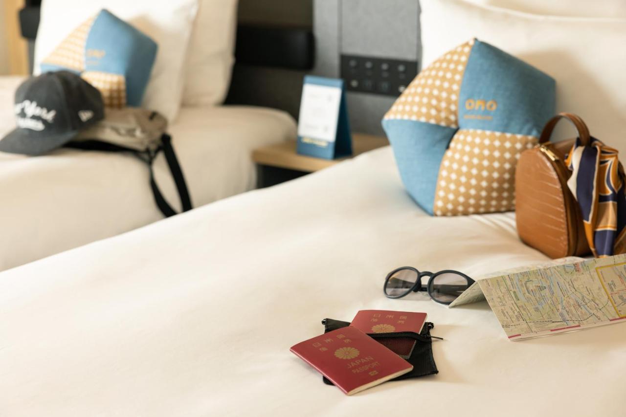 Omo Kansai Airport By Hoshino Resorts Izumisano Buitenkant foto A passport and a boarding pass on a bed
